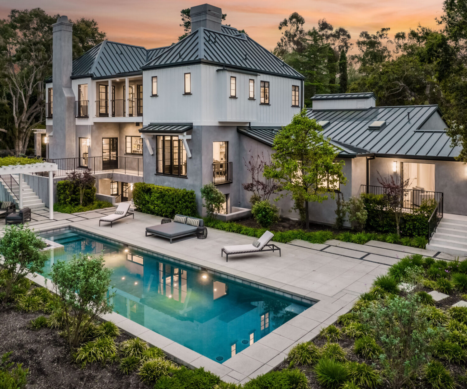 An idyllic residence set in a serene environment, featuring a large roofed structure and a sparkling swimming pool