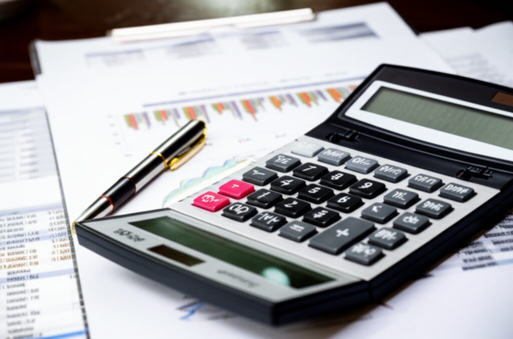 コスト分析書類と電卓が並ぶビジネスデスク
