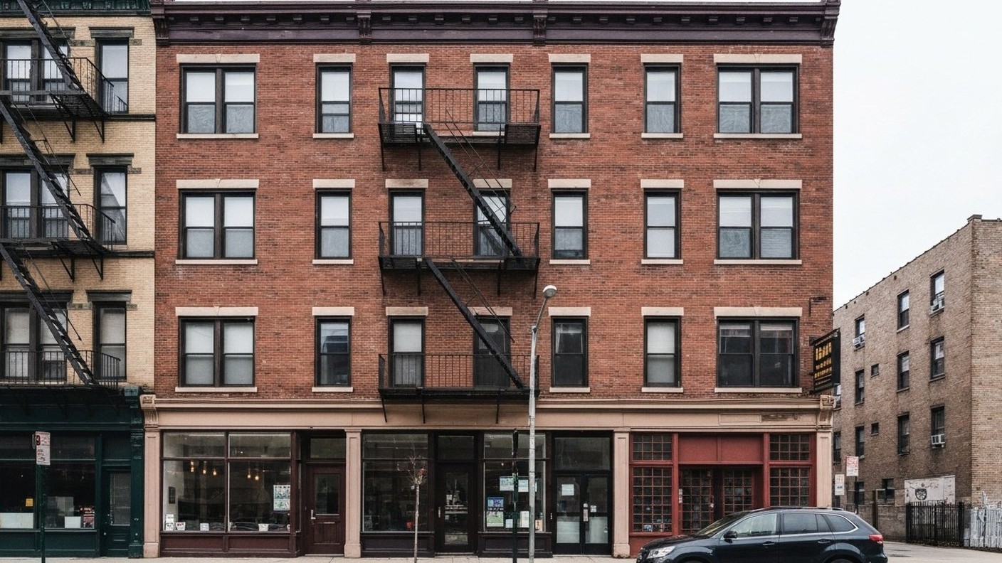 brick pre-war apartment building facade in New Jersey with fire escape and tall windows, street leve